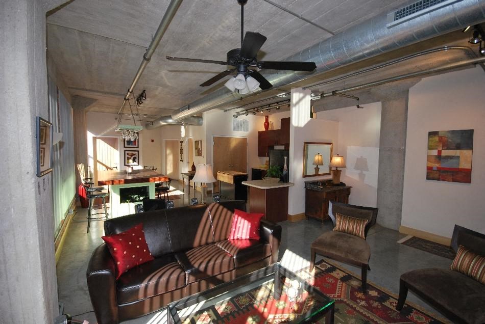 a living room filled with furniture and a ceiling fan