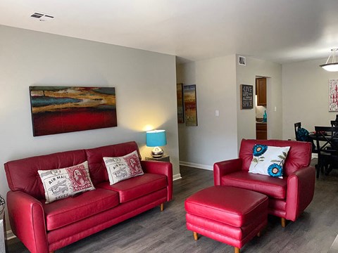 a living room with a red couch and a chair