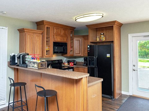 a kitchen with wooden cabinets and a black refrigerator