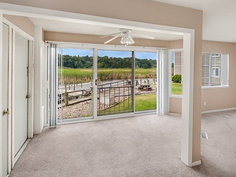 a living room with a view of a balcony and sliding glass doors