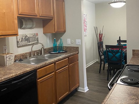 a kitchen with a sink and a stove and a dining room