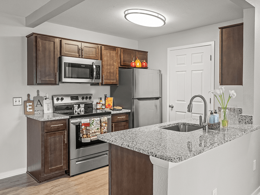 apartment kitchen in Holly Michigan with refrigerator, oven, and microwave - Photo Gallery