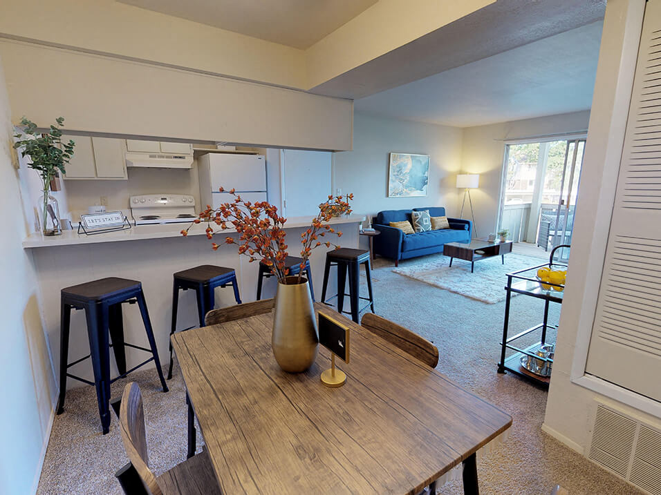 a living room with a dining room table and a kitchen