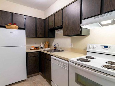 a kitchen with white appliances and dark wood cabinets