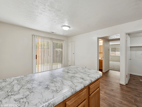 a master bedroom with a marble counter top and wood floors