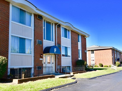 a brick apartment building with a blue awning