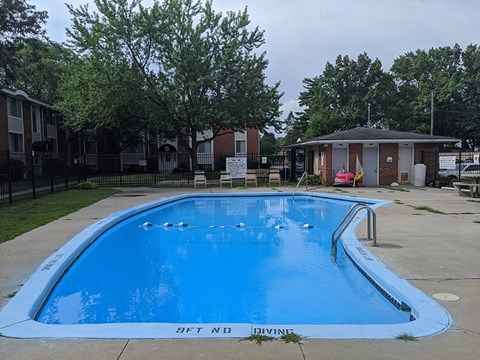 a swimming pool with blue water and a building in the background