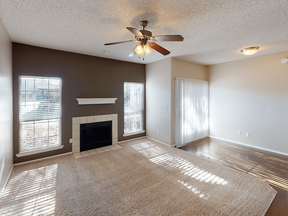 a living room with a fireplace and a ceiling fan