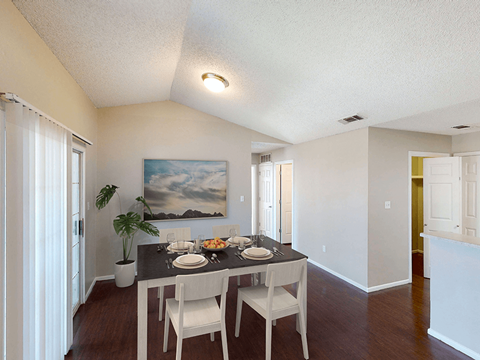 a dining room with a table and chairs and a painting on the wall