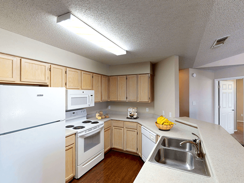 a kitchen with white appliances and wooden cabinets
