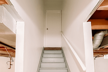 A staircase in a house with a white door at the end.