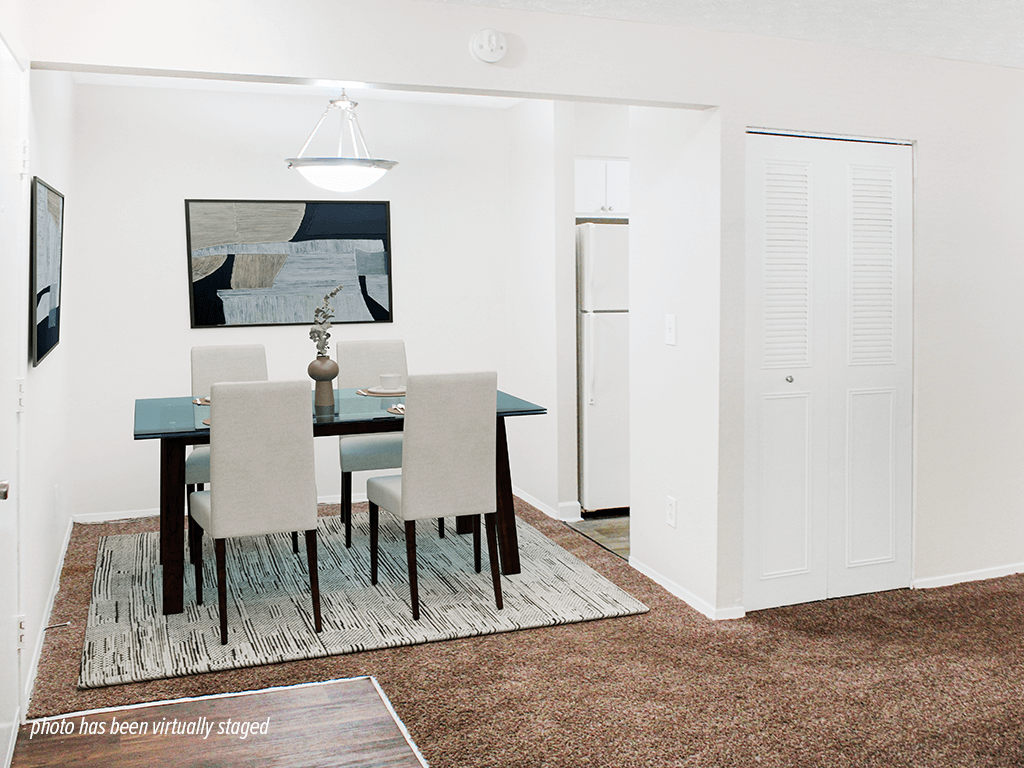 A dining room with a table and chairs.