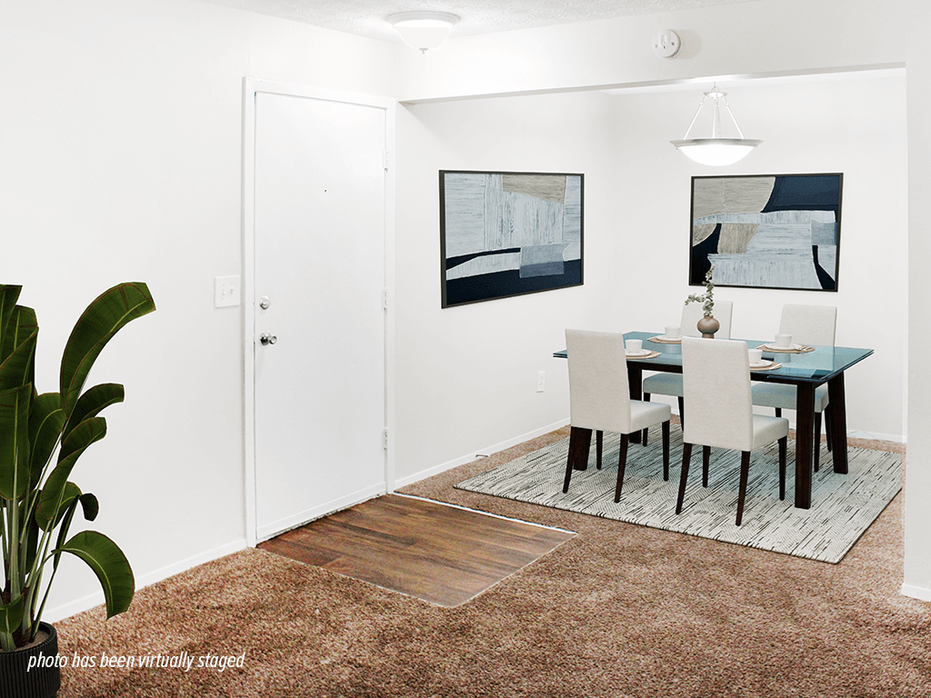 A dining room with a table and chairs.