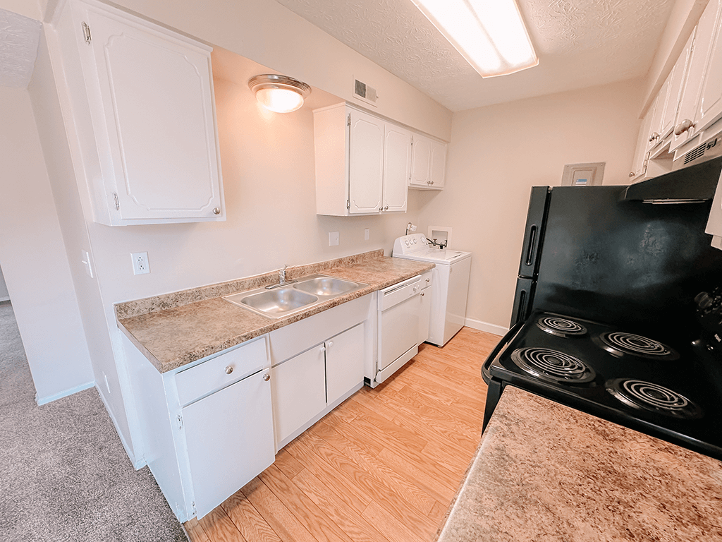 a kitchen with cabinets and a stove and a sink