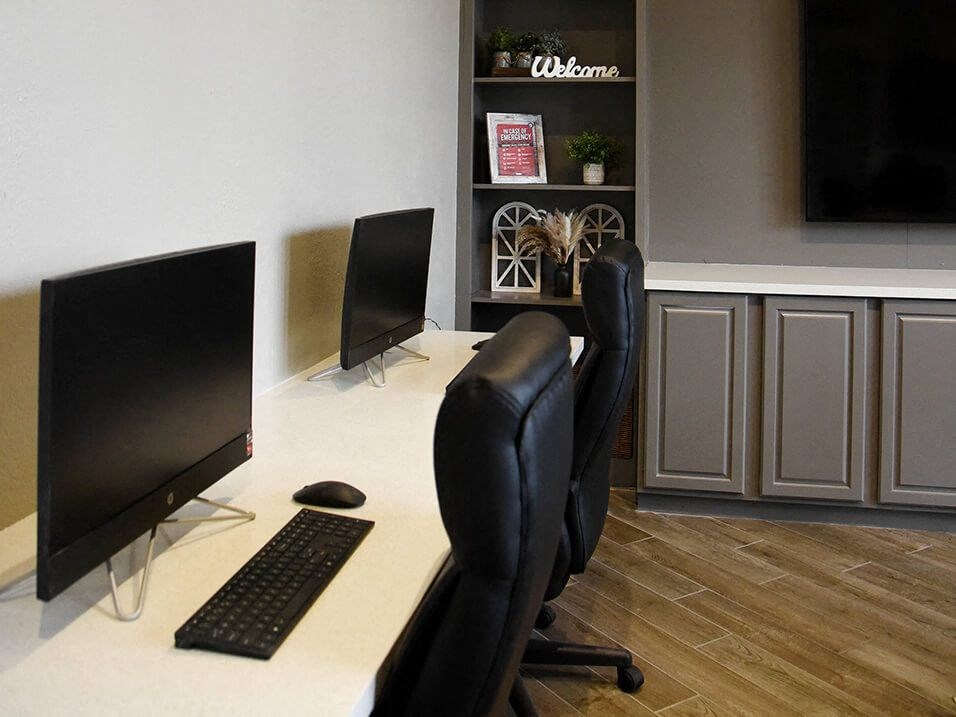 a computer desk with two monitors and a keyboard