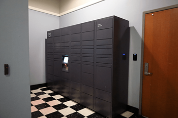A black and white checkered floor in a room with an amazon hub for packages.