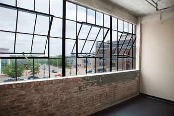 A large window with a view of a parking lot and buildings outside.