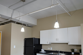 A kitchen with a black fridge and white cabinets.