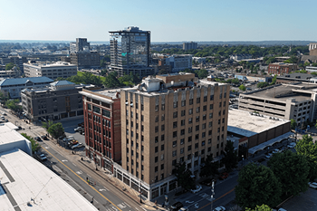 A cityscape with a large building in the foreground and several other buildings in the background.