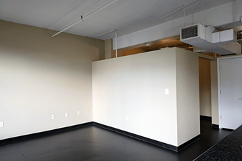 A room with a white wall and a black floor.