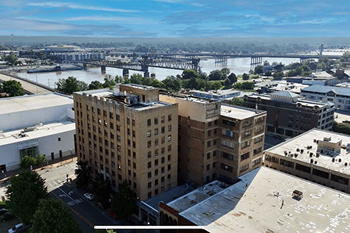 A cityscape with a river and a bridge in the background.