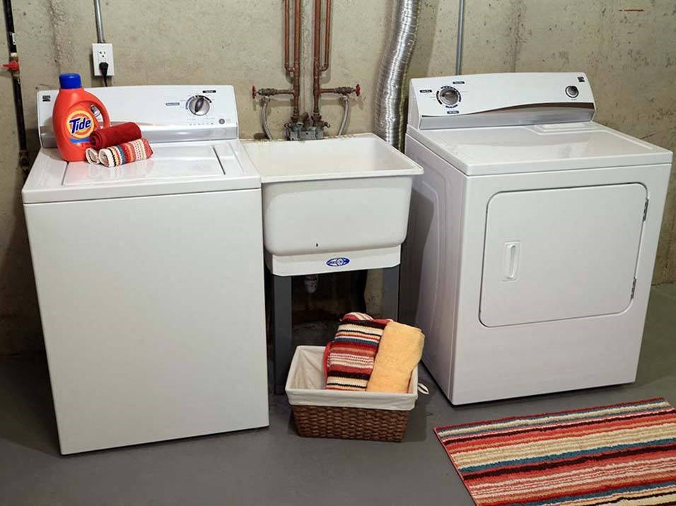 two washing machines and a sink in a laundry room