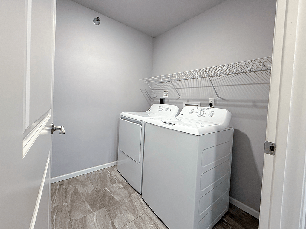 A white bathroom with a double sink and a white cabinet.