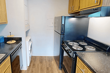 A kitchen with a black stove top oven and a white refrigerator.