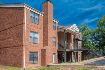 a brick building with a balcony and a blue sky