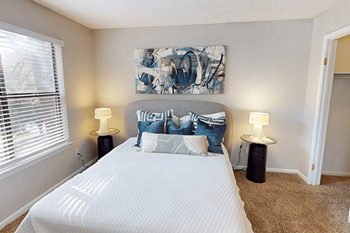 A bedroom with a large bed and a painting on the wall.