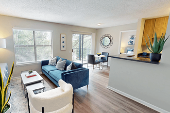 A living room with a blue couch and a white chair.