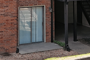 A brick apartment building with a walk out patio