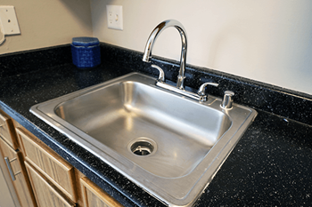 A stainless steel kitchen sink with a chrome faucet.