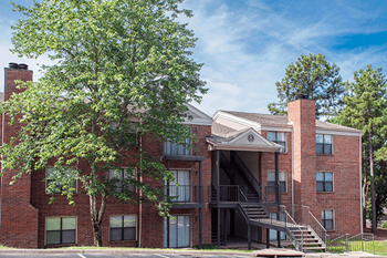 a red brick building with a tree in front of it