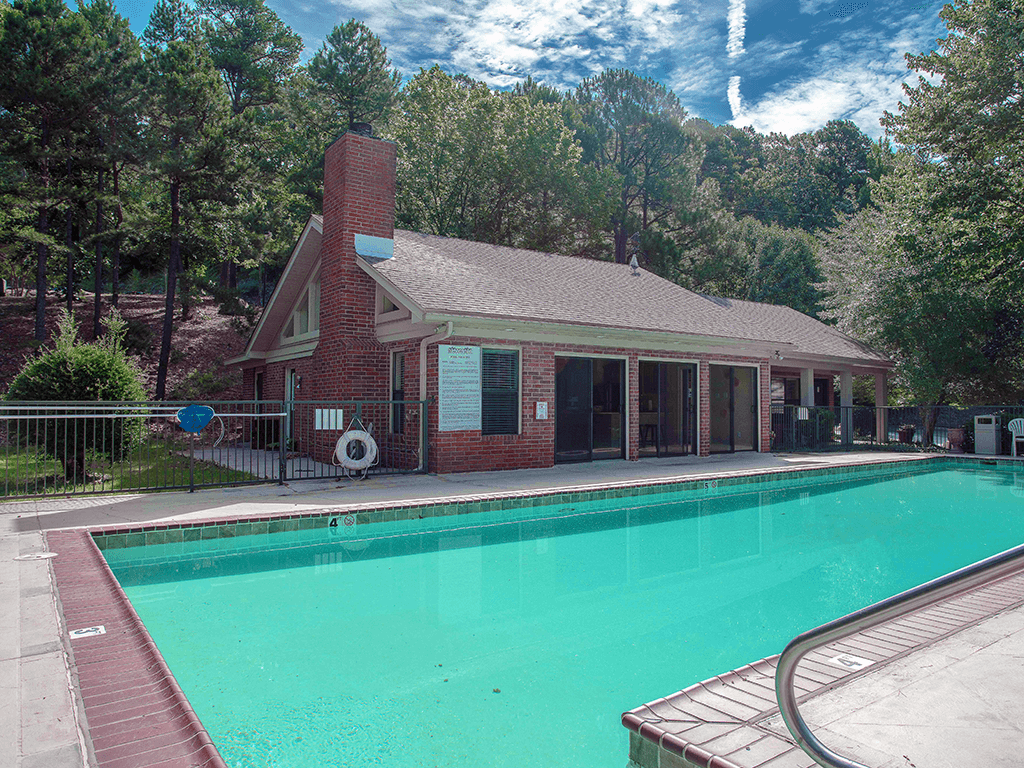 apartment clubhouse with a swimming pool in front of it