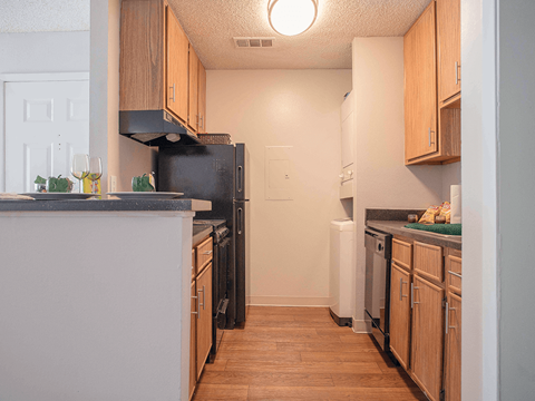 a kitchen with wooden cabinets and a black refrigerator