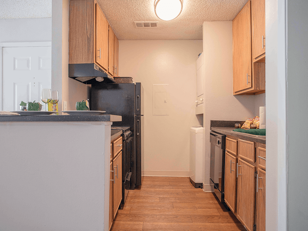 a kitchen with wooden cabinets and a black refrigerator