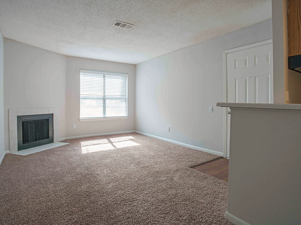 an empty living room with a fireplace and a door