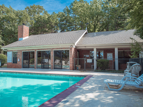 a swimming pool in front of the club house with a pool