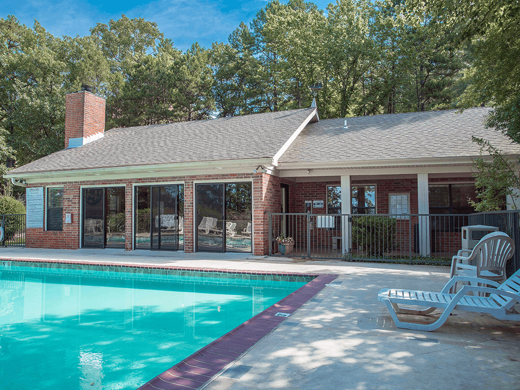 a swimming pool in front of the club house with a pool