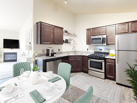 a kitchen with stainless steel appliances and a dining table