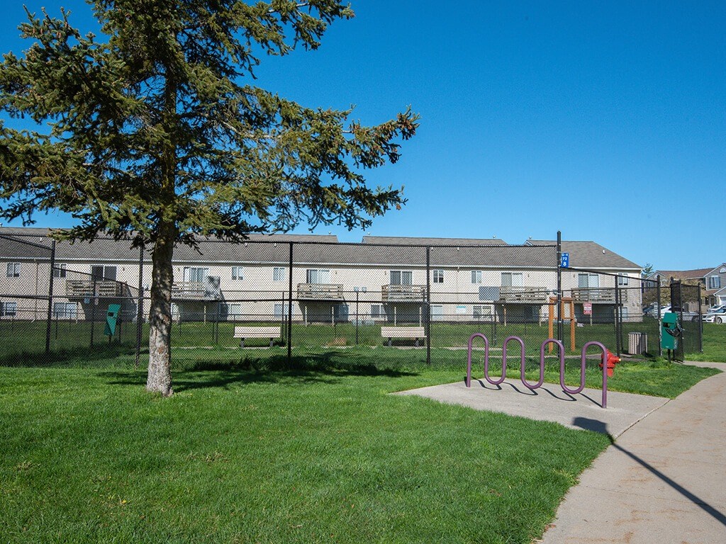 a playground in a park in front of an apartment building