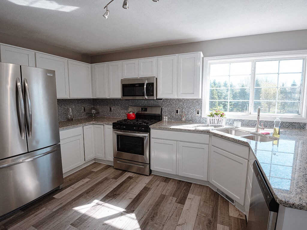 a kitchen with white cabinets and stainless steel appliances