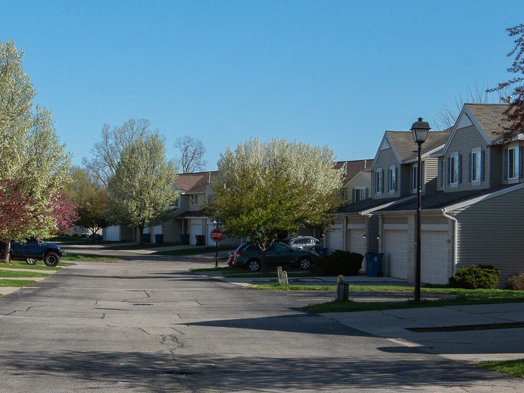 a street in a neighborhood with houses and a stop sign