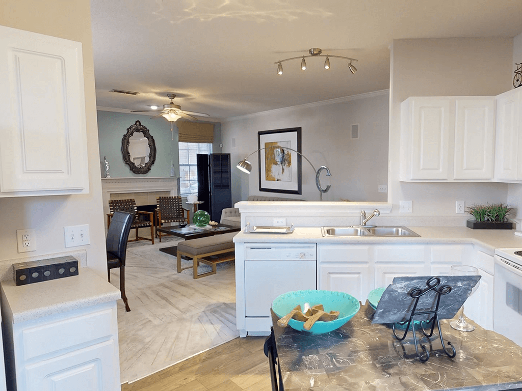 kitchen with white cabinets and living room