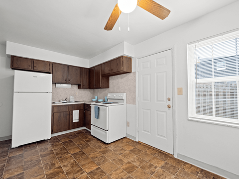 a kitchen with white appliances and wooden cabinets