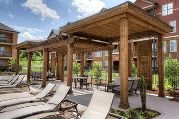 A wooden pavilion with loungers and a slide in the foreground.