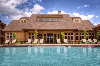 A large house with a pool in front.