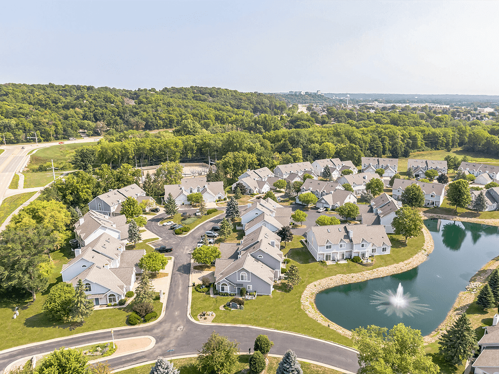 A bird's eye view of a residential neighborhood with houses and a lake.