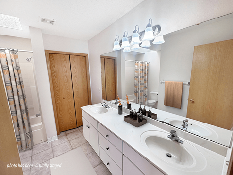 A bathroom with a white counter top and a white sink.